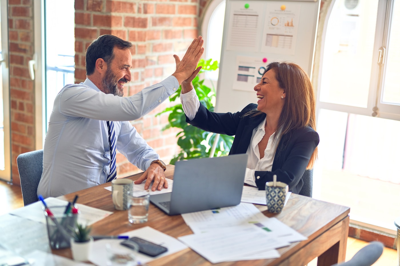 Business professionals celebrating success in modern office